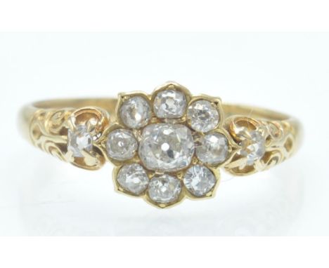 An antique 18ct gold and diamond cluster ring. The ring set with old cut diamonds in a daisy style cluster having diamond set