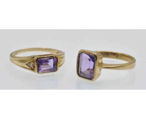 Two hallmarked 9ct gold and amethyst rings. The rings set with emerald cut amethyst one having gem set shoulders. Sizes O and