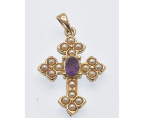 A hallmarked 9ct gold pearl and amethyst cruciform pendant. The pendant in the form of a crucifix set with an oval mixed cut 