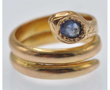 An antique 18ct gold and sapphire snake ring. The ring formed from a coiled snake with sapphire set head and etched scale dec