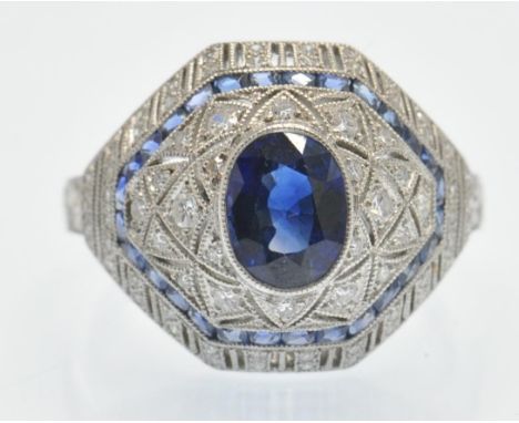 A platinum and sapphire and diamond cocktail ring. The ring set with a central oval mixed cut sapphire, single cut diamonds a