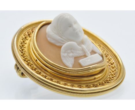 An antique gold Etruscan revival cameo brooch pin. The cameo carved from shell - depicting a figure having shrouded veiled ha