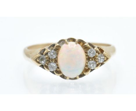 An antique 18ct gold opal and diamond ring. The ring set with an opal cabochon, flanked by six old cut diamonds, within a sca