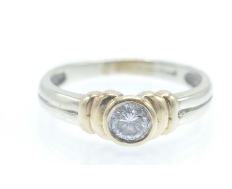 A hallmarked contemporary 18ct gold solitaire diamond ring. The ring having a round brilliant cut diamond in a bezel setting 