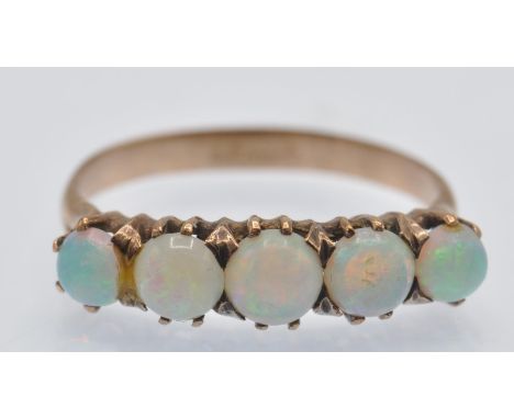 A French gold and opal five stone ring. The ring set with five round opal cabochons in a raised prong setting. Assay mark to 