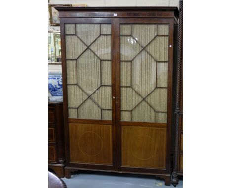 Georgian Mahogany Inlaid Wardrobe, egg and dart pediment moulding over two glazed doors enclosing a brass hanging rail, on br