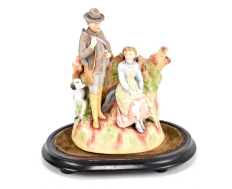 A 19th century Continental hand painted bisque porcelain figure group depicting a gunman or pioneer with his wife and dog, un