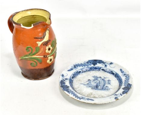 An 18th century Delft plate decorated with a figure hunting, diameter 22.7cm and a 19th century jug, probably Devon with appl