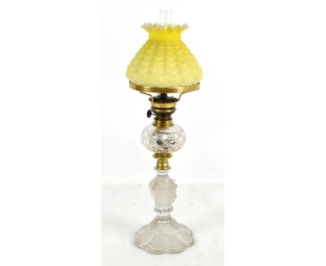 ST LOUIS; an oil lamp with crimped opaque yellow glass shade above clear hobnail cut reservoir on column featuring four busts