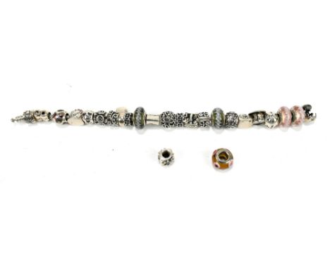 PANDORA; a silver charm bracelet with three stopper charms, and twenty-one assorted charms, including cup and saucer, handbag