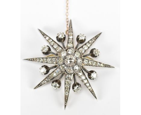 A yellow and white metal diamond starburst pendant/brooch, set with approximately 5.7ct total, the central diamond weighing a