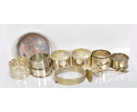 Seven various hallmarked silver napkin rings, a hinged snap bangle, a small pin tray, a baby's push and a triangular shaped m