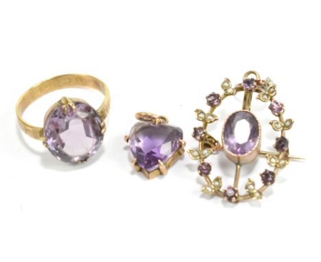 An 18ct yellow gold ring set with pale purple central stone, a similarly decorated pendant/brooch and a heart shaped pendant 