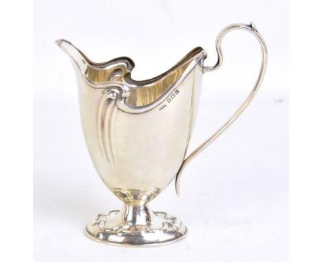 SPURRIER &amp; CO; an Edward VII hallmarked silver Art Nouveau cream jug, with repoussé detail to oval foot, Birmingham 1908,