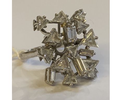 An 18ct white gold and diamond set abstract ring of elaborate construction set with baguette and trillion cut stones in a ste