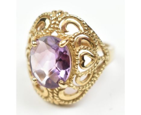 A large 9ct yellow gold dress ring set with purple coloured stone, size N, approx 6.2g.