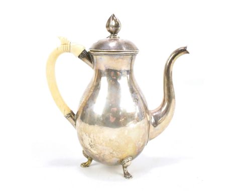 A Russian silver coffee pot of baluster form with hexagonal finial and ivory handle, raised on three hoofed feet, height 22cm