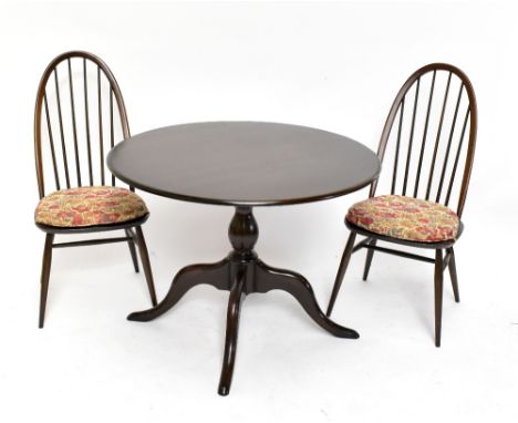 ERCOL; an elm circular dining table, on turned column to four outswept legs, approx 73 x 104cm, and a set of four hoop back c