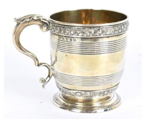 A George III hallmarked silver mug with foliate bands and double scroll handle, with traces of gilding to the interior, on sp