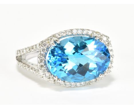 An 18ct white gold blue topaz and diamond ring, the large oval faceted topaz weighing approx 6cts, within a border and framew