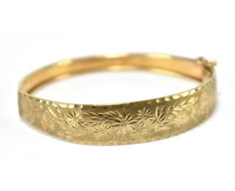 A 9ct yellow gold hinged snap bangle with floral engraved detail, approx 9.5g, internal width approx 6.2cm.Additional Informa