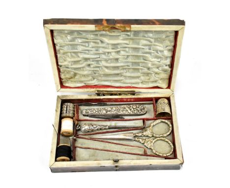 A 19th century tortoiseshell sewing case, the stepped hinged cover with white metal plaque enclosing sewing accessories, leng