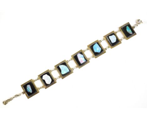 A white metal panel bracelet stamped 'Sterling' to clasp, set with cut sections of opal, length 15.5cm.