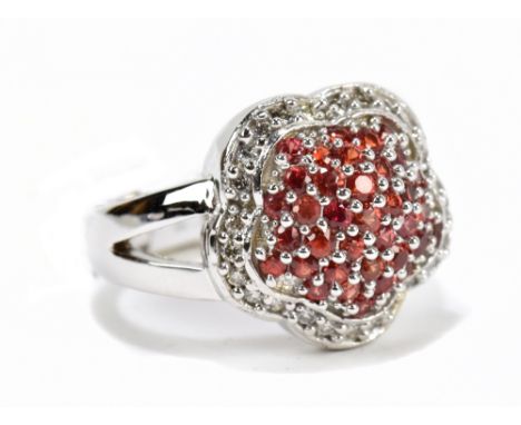 A white metal diamond and red sapphire cluster ring, the round sapphires approx total 1.1ct and the round cut diamonds weighi