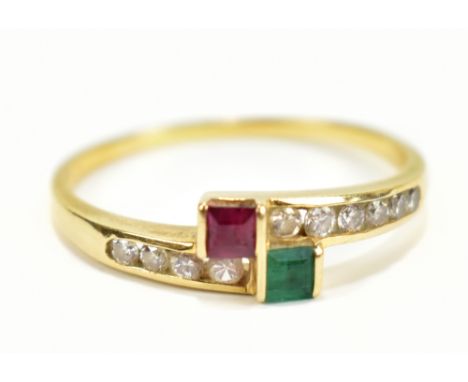 A yellow metal crossover ring set with green, red and white coloured stone, stamped 750 to interior, size P, approx 2.2g.