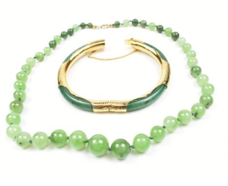 A jade bangle with gold plated mounts, diameter 7.5cm, and a set of graduated beads (2).