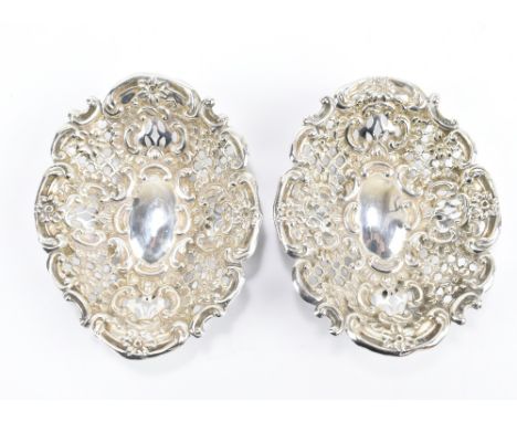 GEORGE UNITE; a pair of Victorian hallmarked silver pierced foliate motif bonbon dishes, each on four ball feet, Birmingham 1