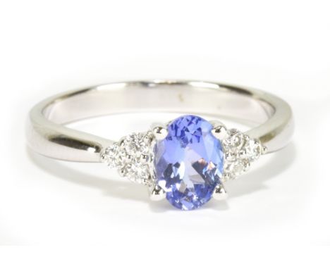 An 18ct white gold tanzanite and diamond ring with central oval tanzanite weighing approx 0.75cts, size L, approx 3.2g.