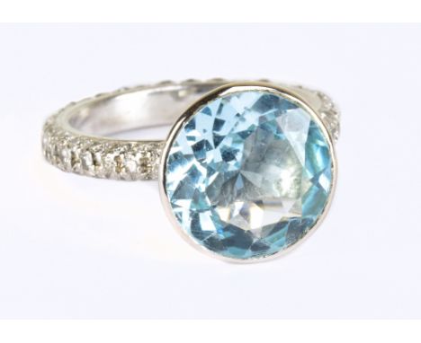 An 18ct white gold blue topaz and diamond ring, the raised collet set topaz weighing approx 5cts with diamonds set to the ent