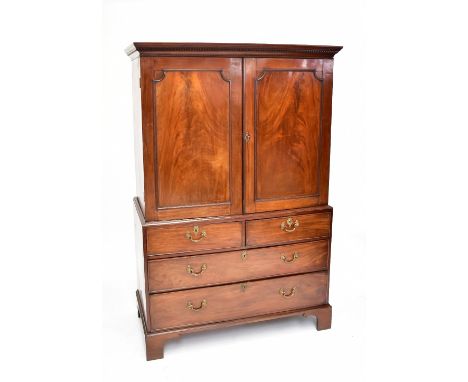 A George III mahogany linen press, the top section with two panelled doors enclosing two drawers above two short and two long