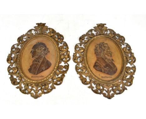 A large pair of late 19th century German cast iron foliate decorated pierced frames each centred with a metal plaque depictin