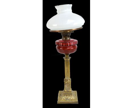 A Victorian brass oil lamp with faceted cranberry glass reservoir and milk glass shade, height 72cm.Additional InformationGen