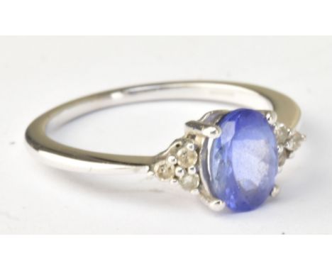 A 9ct white gold dress ring set with oval cut tanzanite and white stone chips, size K, approx 1.8g.Additional InformationLigh