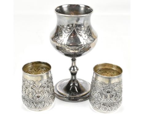 A pair of white metal beakers with repoussé foliate detail, both stamped 'silver' to bases, height 8.5cm, approx 6.5ozt/204.9