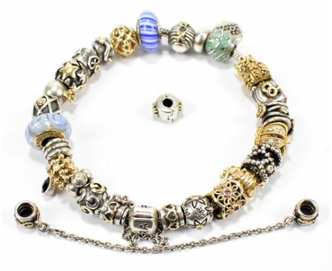 PANDORA; a hallmarked silver charm bracelet featuring seven yellow metal charms all stamped 585 and further silver and silver