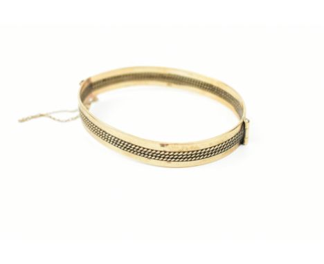 A 9ct yellow gold hinged snap bangle, with safety chain, approx 17.4g.