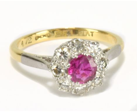 An 18ct yellow gold diamond and ruby cluster ring, the ruby weighing approx 0.25ct within a border of eight diamonds, size L,