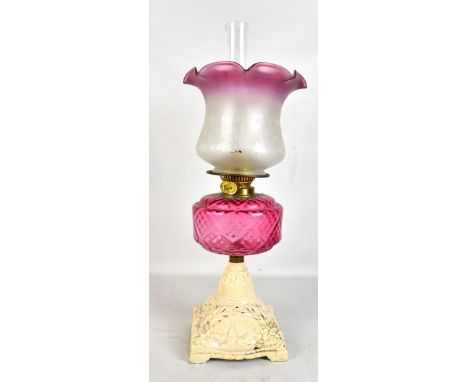A late 19th century oil lamp, with cranberry glass reservoir and pierced metal base, height 57cm.Additional InformationPaint 