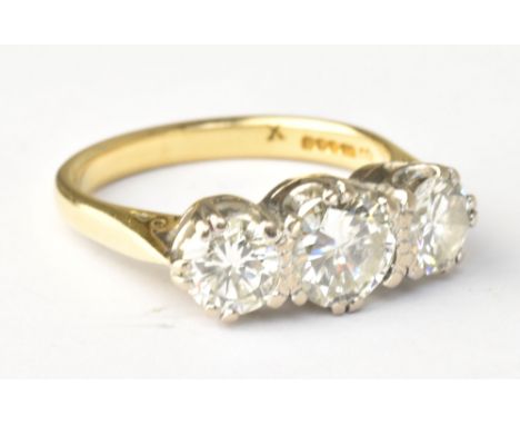 An 18ct yellow gold and diamond three stone ring, the central round brilliant cut stone weighing approx 1ct flanked by twin s