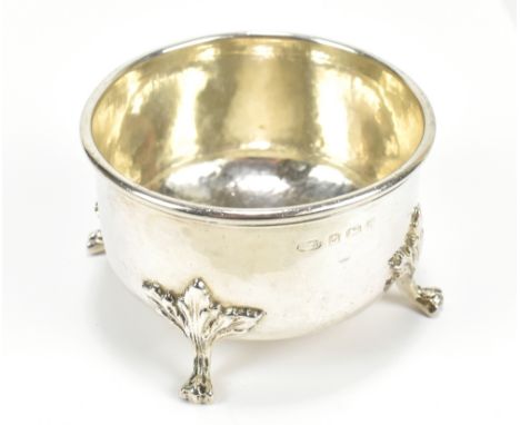 ALBERT EDWARD JONES: a George V hallmarked silver circular bowl, with hammered finish, on four paw feet, no.750 to base, Birm