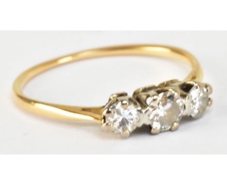 A yellow metal and diamond three stone ring, the central stone weighing approx 0.25ct, size N, approx 1.6g.