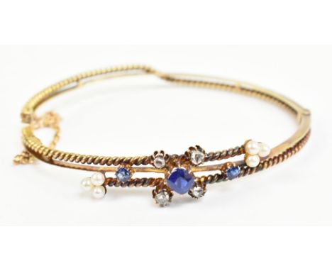 A late Victorian/Edwardian yellow metal diamond seed pearl and sapphire hinged snap bangle, unmarked (af), approx 10.7g.Addit