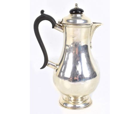 An Edward VII hallmarked silver hot water pot with ebonised finial and handle, on spreading circular foot, stamped 'Carringto