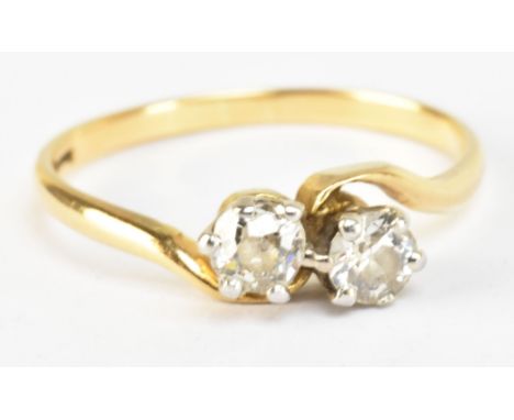 A yellow metal and diamond two stone crossover ring, each stone weighing approx 0.25ct, marked to band interior, size M, appr