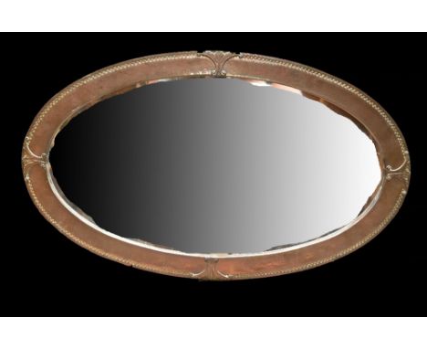 An Arts and Crafts copper framed oval mirror with hammered finish and bevelled glass, 80 x 47cm.Additional InformationLight g