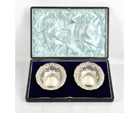 FLORENCE WARDEN; a cased pair of Victorian hallmarked silver pierced bonbon dishes with repousse foliate detail, Chester 1898